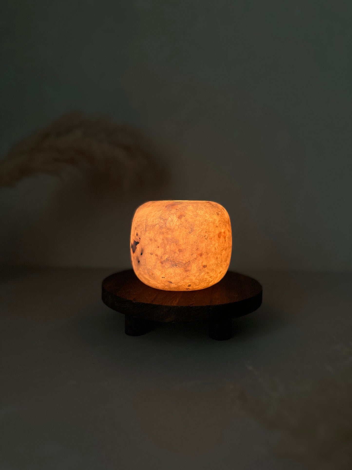 White Alabaster bowl on a wooden stand in the dark