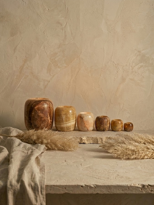Set of Brown Alabaster Candle holders on a textured surface with a neutral background